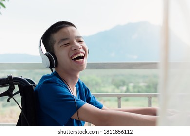 Disabled Child On Wheelchair Wearing Headphone Listen To Music In The House,Study And Work At Home For Safety From Covid 19,Life In The Education Age Of Special Need Kid, Happy Disability Boy Concept.