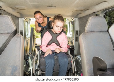 A Disabled Child In A Wheelchair Being Helped Into A Specially Adapted Van / Working With Disability