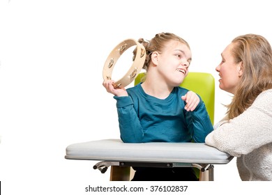 Disabled Child In A Wheelchair Having Music Therapy Together With A Special Needs Carer / Working With Mentally Handicapped Children