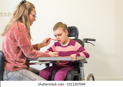 A Disabled Child In A Wheelchair Together With A Voluntary Care Worker