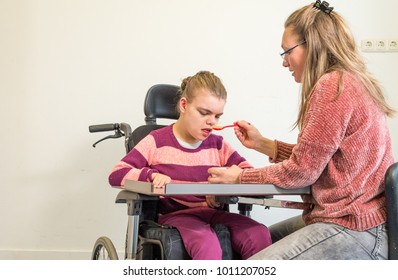 A Disabled Child In A Wheelchair Together With A Voluntary Care Worker