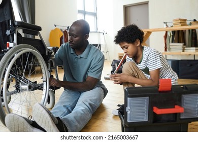 Disabled Dad Fixing Wheelchair With His Son