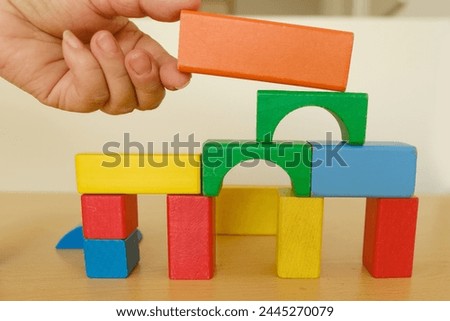 disabled elderly womans hands plays wooden geometric figures, blocks, fine motor skills training, manual dexterity, exercises developing brain, prevention dementia and alzheimer's disease, support