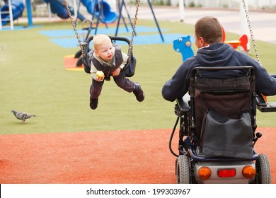Disabled Father play with his little son on the playground.