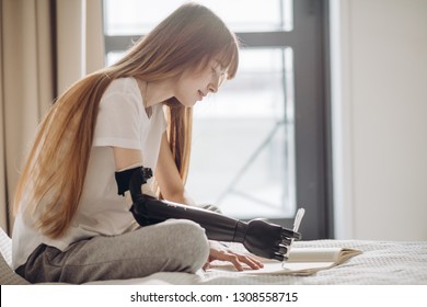 disabled female student writing a report. close up photo. copy space