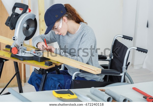 trabajadora discapacitada en silla de ruedas en un taller de carpinteros