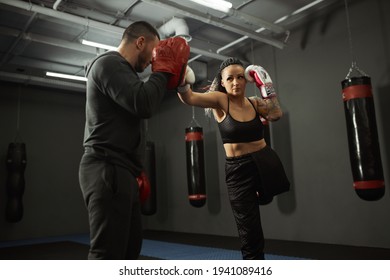 A disabled girl is engaged in the gym. a woman with one leg trains with a trainer in boxing, she learns to fight - Powered by Shutterstock