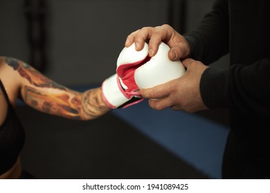 A disabled girl is engaged in the gym. a woman with one leg trains with a trainer in boxing, she learns to fight - Powered by Shutterstock