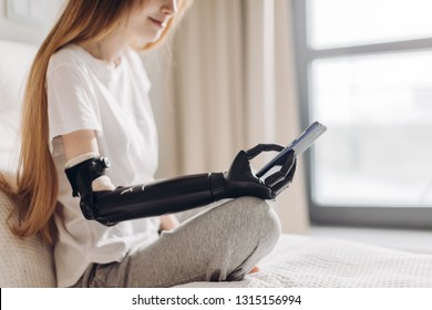 Disabled Girl Holding Her Mobile Phone With A Robotic Arm. Close Up Side View Photo. Copy Space. Connection, Communication,wi-fi