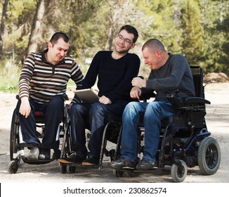 Disabled Happy Friends With Ipad Outside