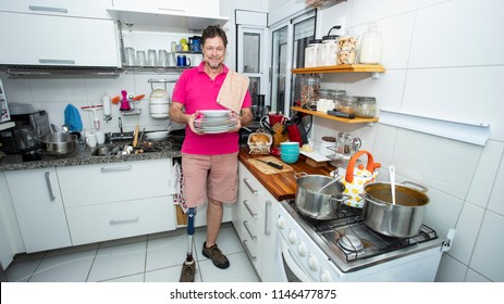 Disabled. Isolated man without leg. cleaning the kitchen  - Powered by Shutterstock