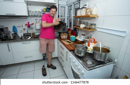 Disabled. Isolated man without leg. cleaning the kitchen  - Powered by Shutterstock