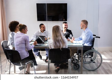 Disabled Male Manager Sitting With His Colleagues At Workplace - Shutterstock ID 1164154957
