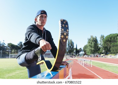 Disabled man athlete stretching with leg prosthesis. Paralympic Sport Concept. - Powered by Shutterstock