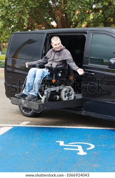 Disabled man on wheelchair car\
lift