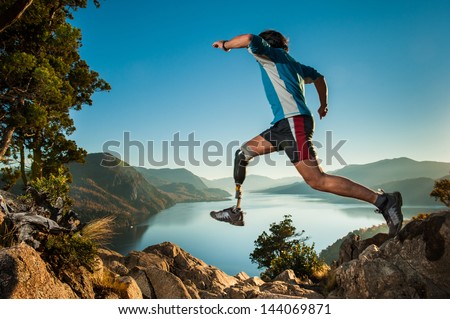 Disabled man with prosthetic leg, jumping in Patagonia.
