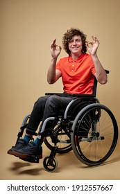 disabled man showing ok gesture, curly caucasian male smiling, doesn't give up, isolated portrait