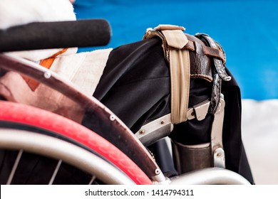 Disabled Man Sitting On The Wheelchair With Old Polio Knee Caliper Brace.