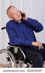 Disabled Man Sitting In A Wheelchair And Talking On The Phone