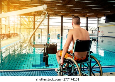Disabled man in a swimming pool. Wheelchair. Disabled man in a wheelchair.