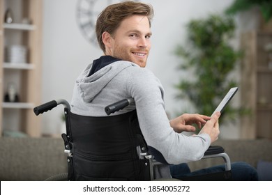 Disabled Man Using Tablet Looking Back Over His Shoulder