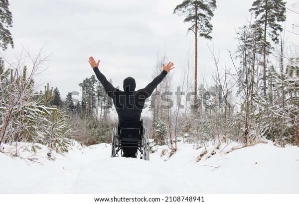 a disabled man in a\
wheelchair, with a spinal injury, solitude with nature on a winter\
day, meditation