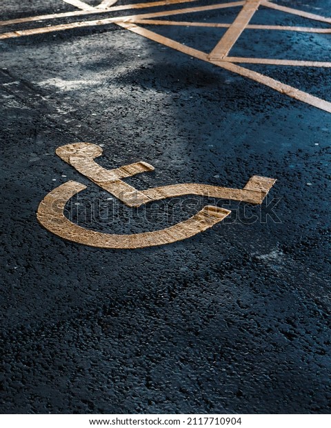 Disabled parking. Accessible parking\
spot. Blue badge. Yellow wheelchair sign on the\
ground
