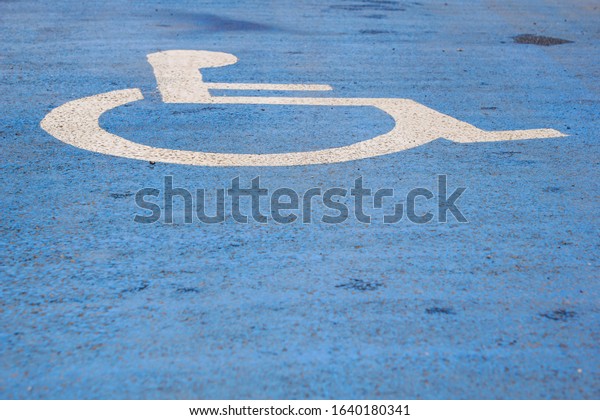Disabled parking space designated on a road with\
blue and white