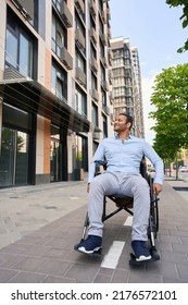 Disabled Person Moving In Wheelchair On Sidewalk