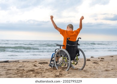 Disabled person on his back in a wheelchair on the beach with open arms enjoying the freedom - Powered by Shutterstock