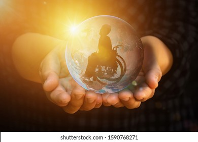 Disabled person on wheelchair in earth holding in human hands towards goals city across active work. International Disability Day or Handicapped Paralympics. Autistic Awareness Day and health concept. - Powered by Shutterstock