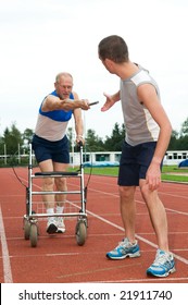 Disabled Person Reaching For An Other Athlete To Pass Him The Baton. Caricature Picture To Illustrate Helping, Giving, Disability, Ability, Getting Older, Not Wanna Quit.