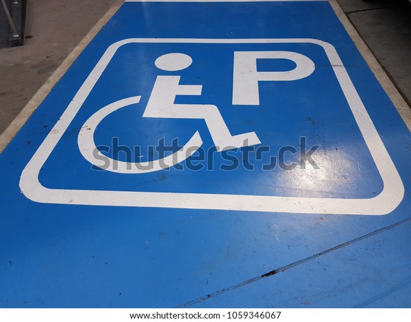 Disabled person sign parking for wheelchair\
on floor background.