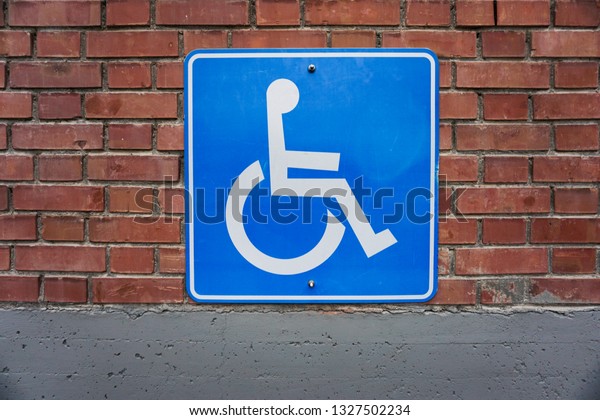 Disabled Person Sign, Wheelchair Symbol, Brick\
Wall Background