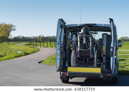 A disabled person in a wheelchair being lifted into a specially adapted vehicle