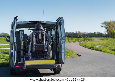 A disabled person in a wheelchair being lifted into a specially adapted vehicle