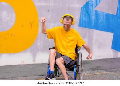 Disabled person in a wheelchair listening to music with headphones, dancing and smiling - Powered by Shutterstock