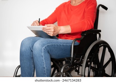 Disabled Person in a Wheelchair on a White Background Drawing on a Digital Tablet. - Powered by Shutterstock