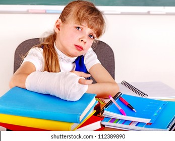 Disabled Sad Child With Broken Arm In Classroom.