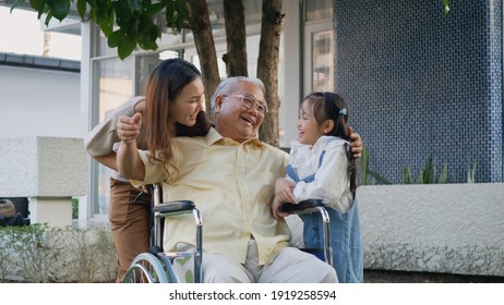 Disabled Senior Grandpa On Wheelchair With Grandchild And Mother In Park, Happy Asian Three Generation Family Having Fun Together Outdoors Backyard, Grandpa And Little Child Smiling And Laughed