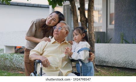 Disabled Senior Grandpa On Wheelchair With Grandchild And Mother In Park, Happy Asian Three Generation Family Having Fun Together Outdoors Backyard, Grandpa And Little Child Smiling And Laughed