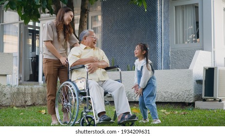 Disabled Senior Grandpa On Wheelchair With Grandchild And Mother In Park, Happy Asian Three Generation Family Having Fun Together Outdoors Backyard, Grandpa And Little Child Smiling And Laughed