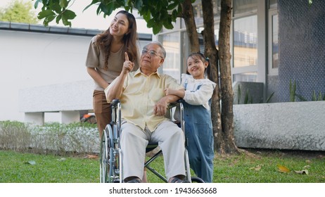 Disabled Senior Grandpa On Wheelchair With Grandchild And Mother In Park, Happy Asian Three Generation Family Having Fun Together Outdoors Backyard, Grandpa And Little Child Smiling And Laughed