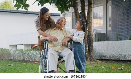 Disabled Senior Grandpa On Wheelchair With Grandchild And Mother In Park, Happy Asian Three Generation Family Having Fun Together Outdoors Backyard, Grandpa And Little Child Smiling And Laughed