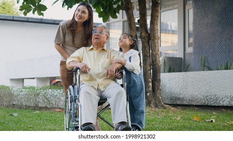 Disabled Senior Grandpa On Wheelchair With Grandchild And Mother In Park, Happy Asian Three Generation Family Having Fun Together Outdoors Backyard, Grandpa And Little Child Smiling And Laughed