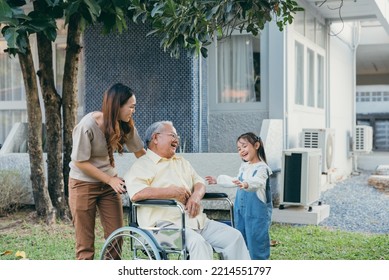 Disabled Senior Grandpa On Wheelchair With Grandchild And Mother In Park, Happy Asian Multi Generation Family Having Fun Together Outdoors Backyard, Grandpa Elderly And Little Child Smiling And Laugh.