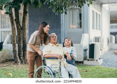 Disabled Senior Grandpa On Wheelchair With Grandchild And Mother In Park, Happy Asian Multi Generation Family Having Fun Together Outdoors Backyard, Grandpa Elderly And Little Child Smiling And Laugh.