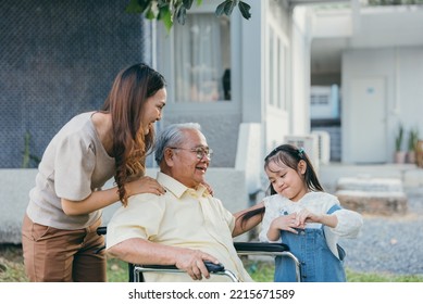 Disabled Senior Grandpa On Wheelchair With Grandchild And Mother In Park, Happy Asian Multi Generation Family Having Fun Together Outdoors Backyard, Grandpa Elderly And Little Child Smiling And Laugh.