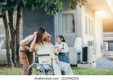 Disabled Senior Grandpa On Wheelchair With Grandchild And Mother In Park, Happy Asian Multi Generation Family Having Fun Together Outdoors Backyard, Grandpa Elderly And Little Child Smiling And Laugh.