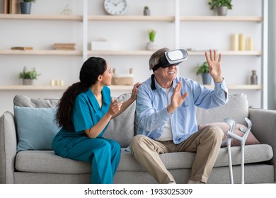 Disabled senior man using VR headset with young nurse, exploring augmented reality at home. Elderly male patient with doctor playing virtual game, having fun with futuristic technologies - Powered by Shutterstock